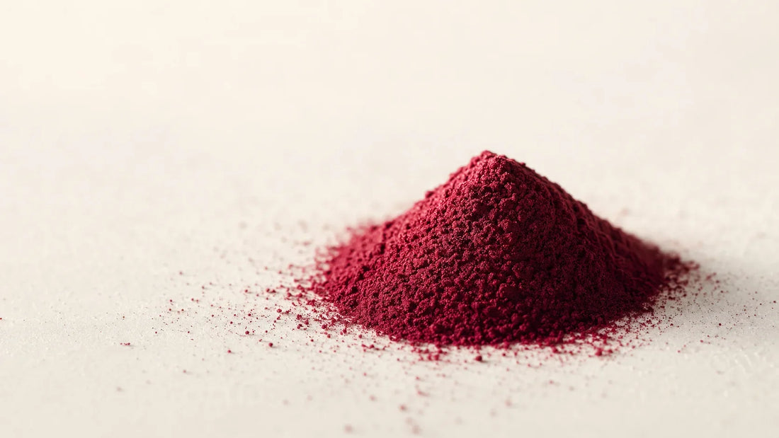 Feines Rote-Bete-Pulver in tiefem Rot auf weißem Untergrund, Nahaufnahme der Pulverstruktur
